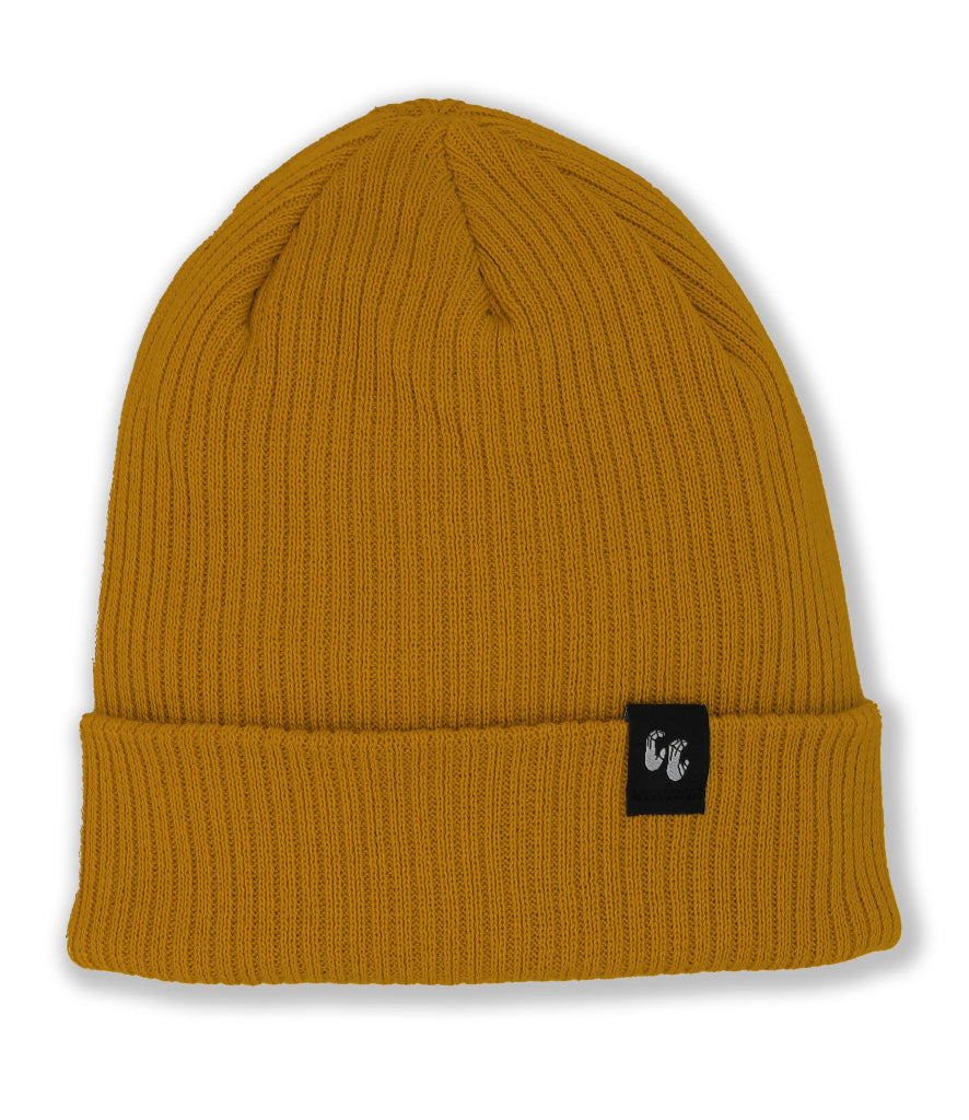 A mustard yellow knitted beanie hat laid down flat with the photo taken from above. The hat is made from Organic Cotton and has a small, black, fabric label stitched to the top of the cuff. The label has a graphic of two hands, the Crimp'd Clothing logo in white