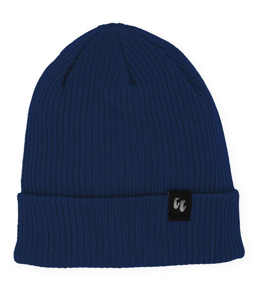 A navy blue knitted beanie hat laid down flat with the photo taken from above. The hat is made from Organic Cotton and has a small, black, fabric label stitched to the top of the cuff. The label has a graphic of two hands, the Crimp'd Clothing logo in white