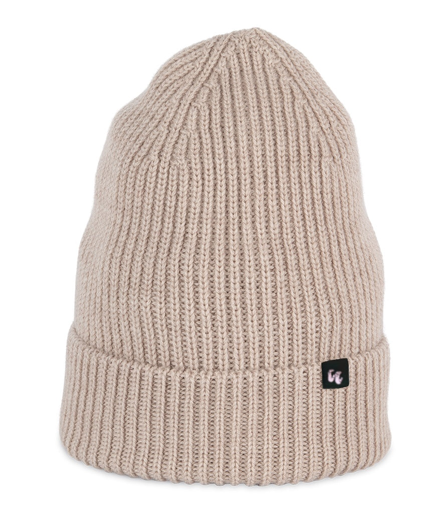 A dark sand-beige beanie with chunky, fisherman-style ribbed knit. It has a black fabric label with a white logo stitched to the cuff