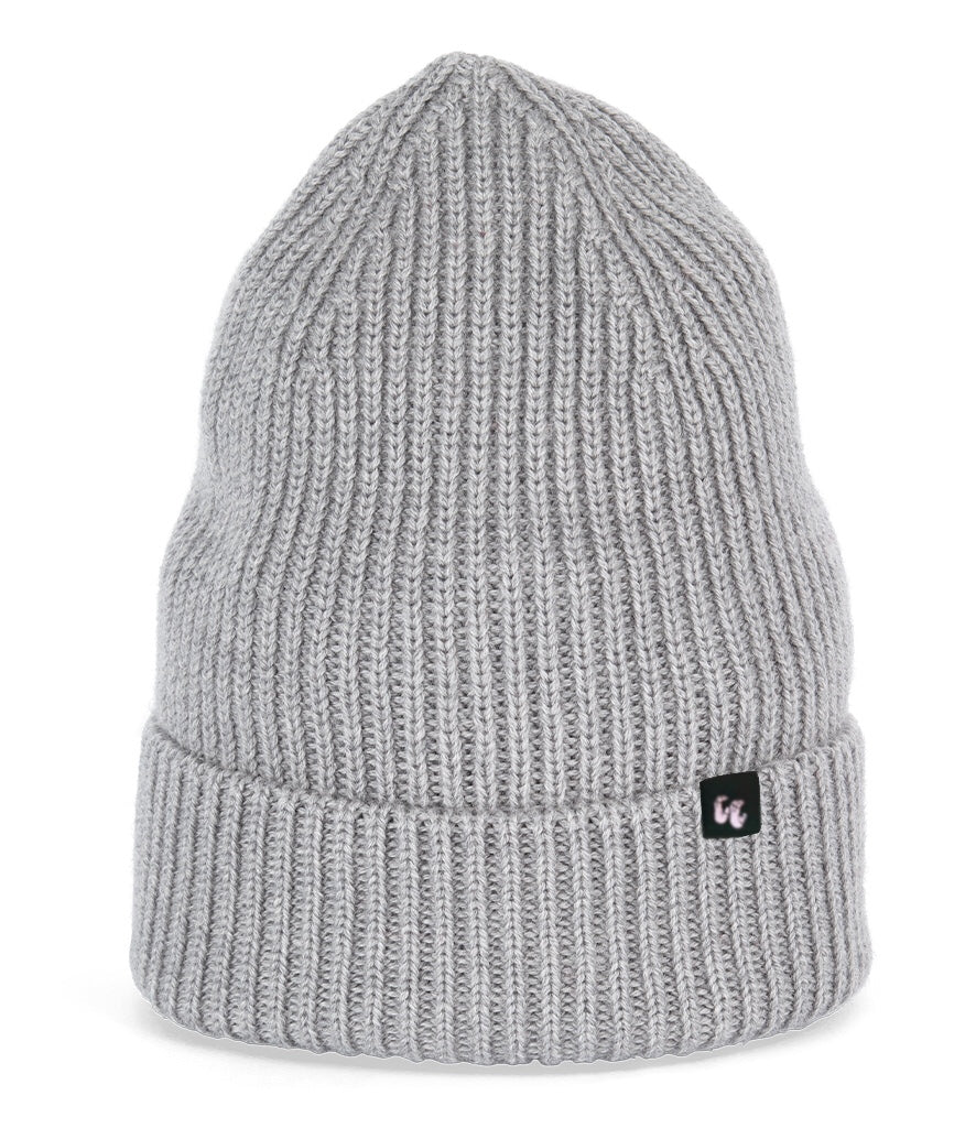 A light grey beanie with chunky, fisherman-style ribbed knit. It has a black fabric label with a white logo stitched to the cuff