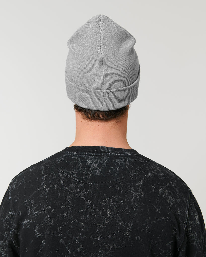 The rear-view of a person wearing a mid-grey beanie hat and black t-shirt